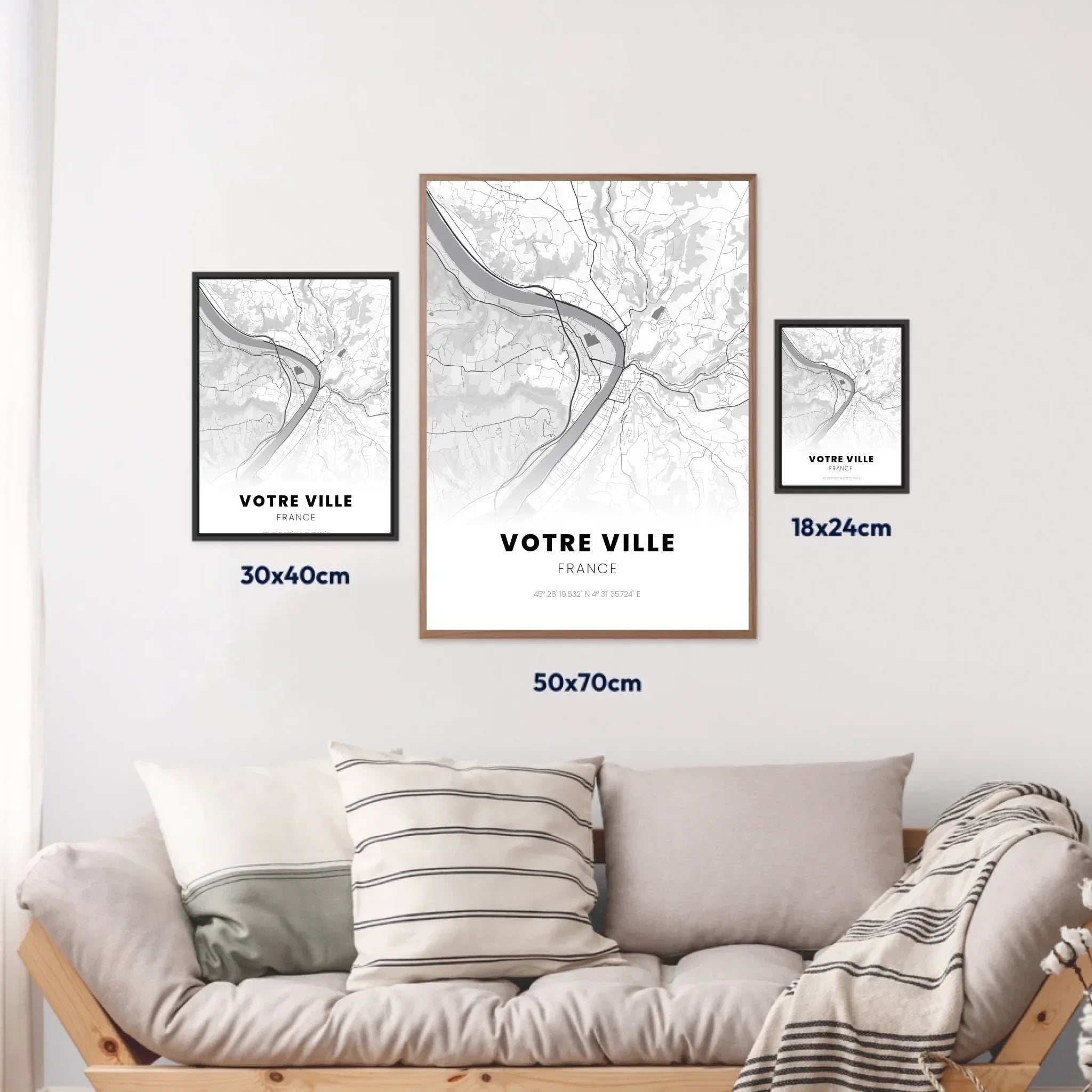 Affiches personnalisées de ville en noir et blanc, trois formats présentés au mur au-dessus d’un canapé.