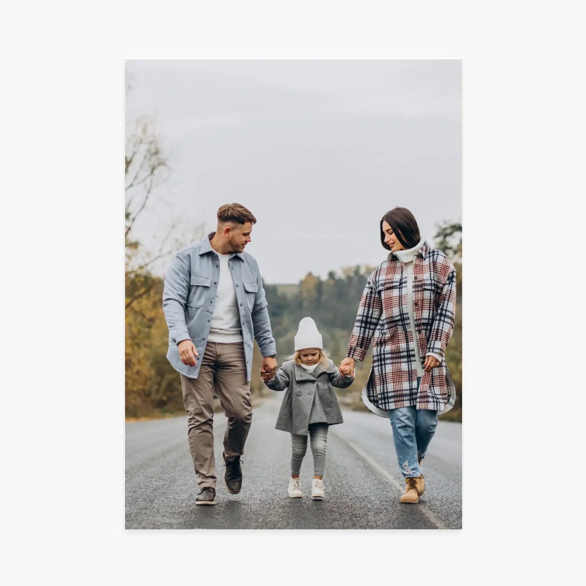 Famille marchant sur une route, parents tenant la main de leur enfant, automne, vêtements chauds
