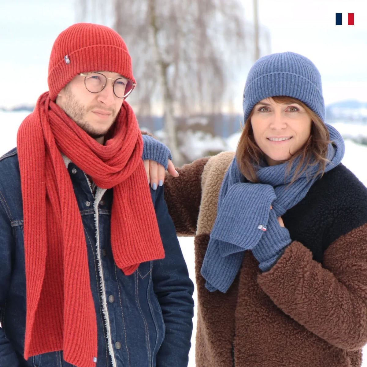 Deux personnes portant bonnets et écharpes en laine made in France dans la neige