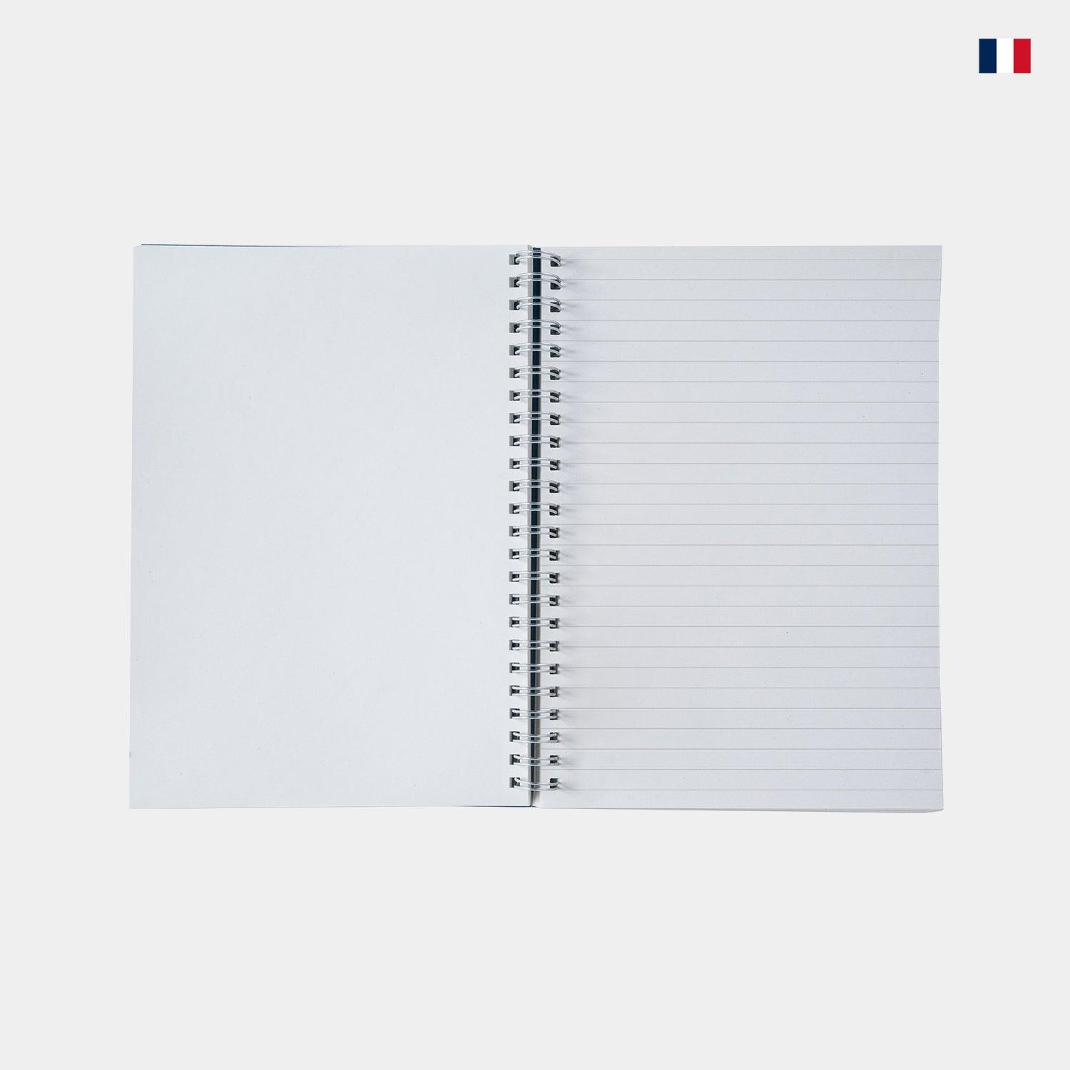 Carnet A5 en cuir ouvert, pages blanches et lignées, spirale, sur fond clair.