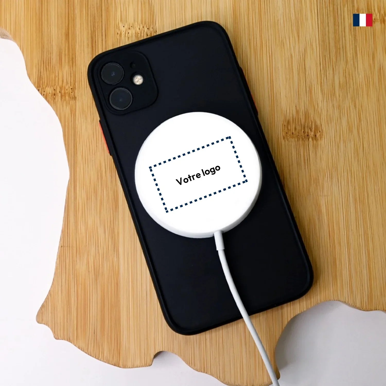 Chargeur MagSafe personnalisé posé sur smartphone noir, fond bois, texte Votre logo.