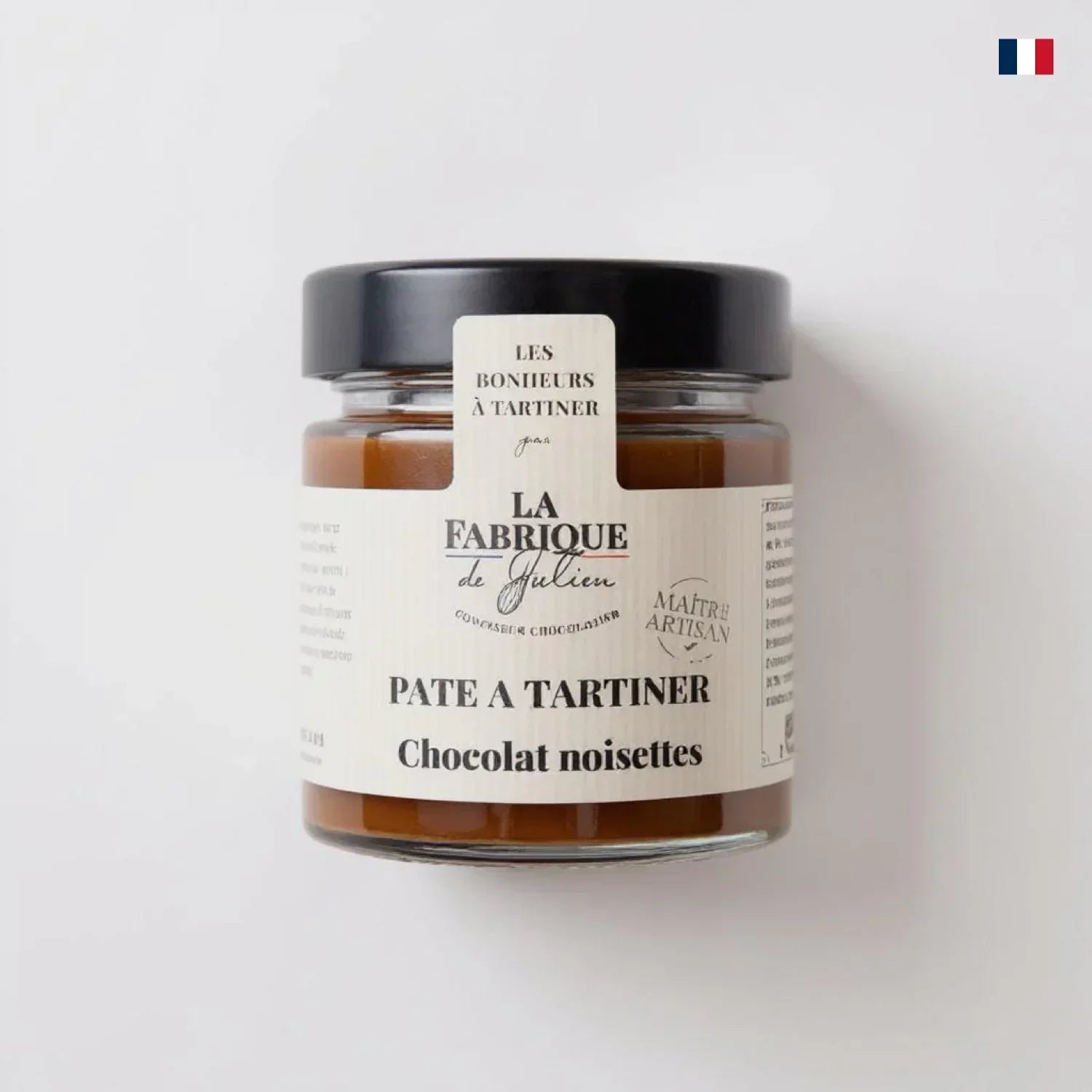 Pot de pâte à tartiner chocolat noisettes artisanale, couvercle noir, fond blanc.