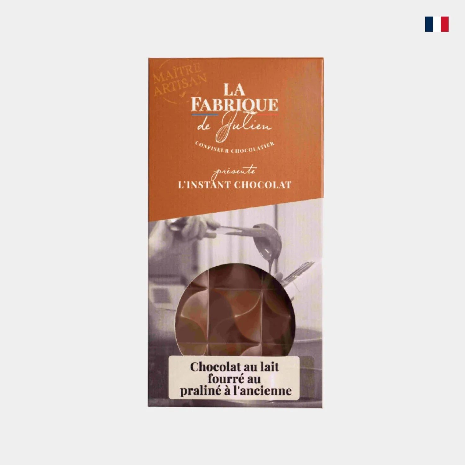Tablette chocolat au lait fourré praliné dans son emballage artisanal avec fenêtre ronde.