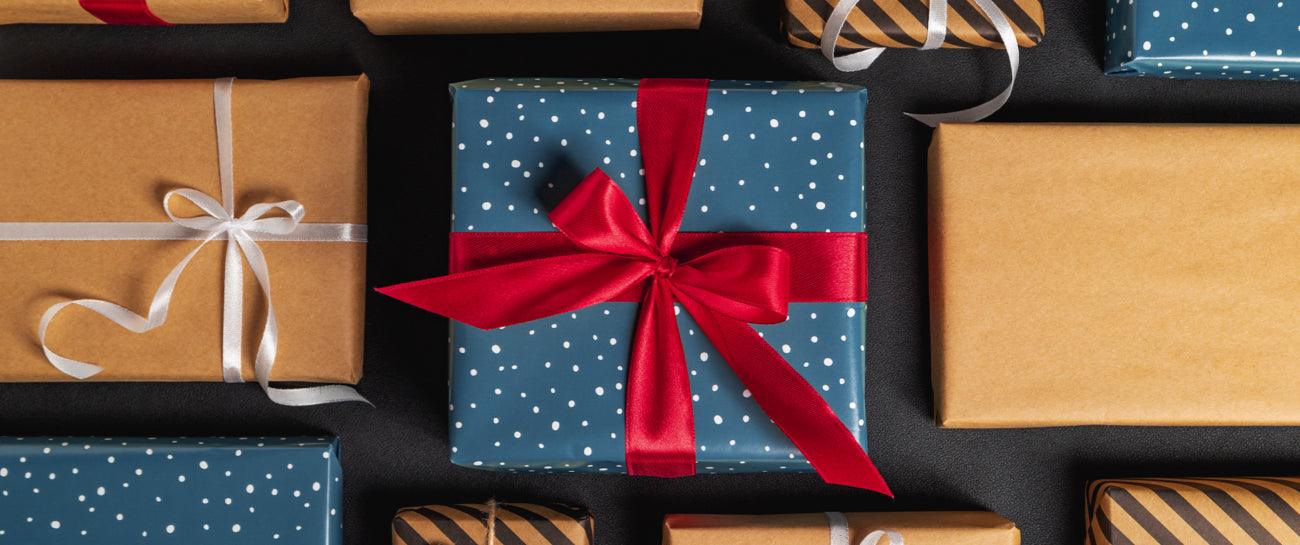 Cadeaux emballés, papier bleu à pois et kraft, rubans, idée cadeau personnalisé