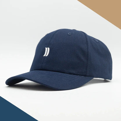 Casquette classique bleu marine en coton avec logo brodé blanc, fond épuré.